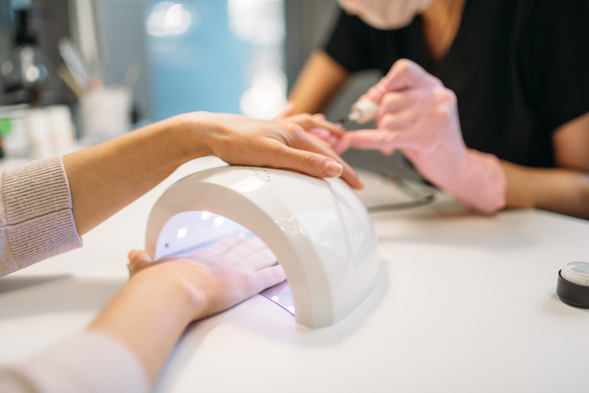 Female Client Dries Gel Varnish in the Nail Dryer